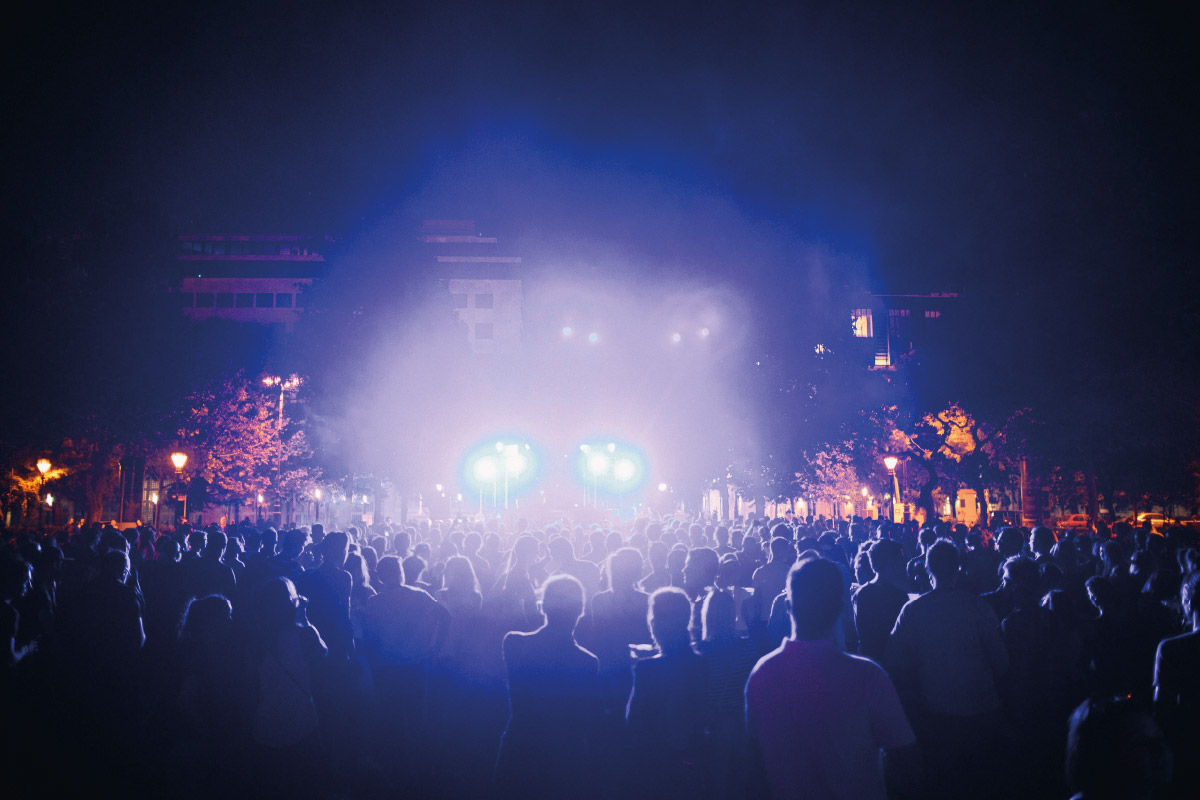 Multitud iluminada por reflectores en un concierto de MAXIEVENTOS DRM